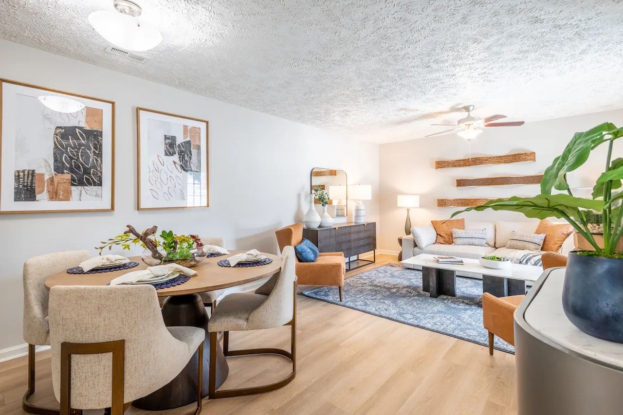 Bright, modern living-dining room with neutral tones, abstract art, and cozy seating arrangements.